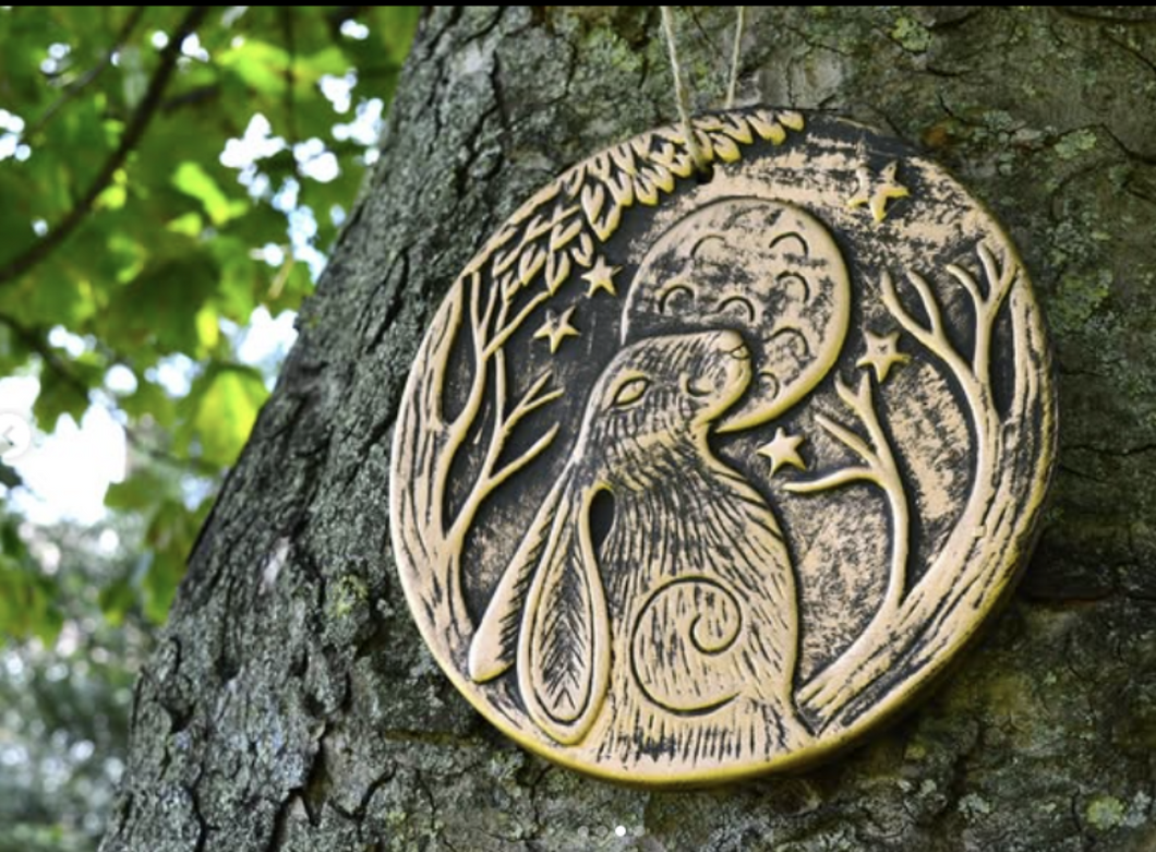 Decorative plaque with a rabbit design on a tree trunk www.karmaripon.co.uk