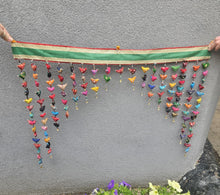 Load image into Gallery viewer, Colourful hanging decorative item with beads and small figures on a grey background www.karmaripon.co.uk